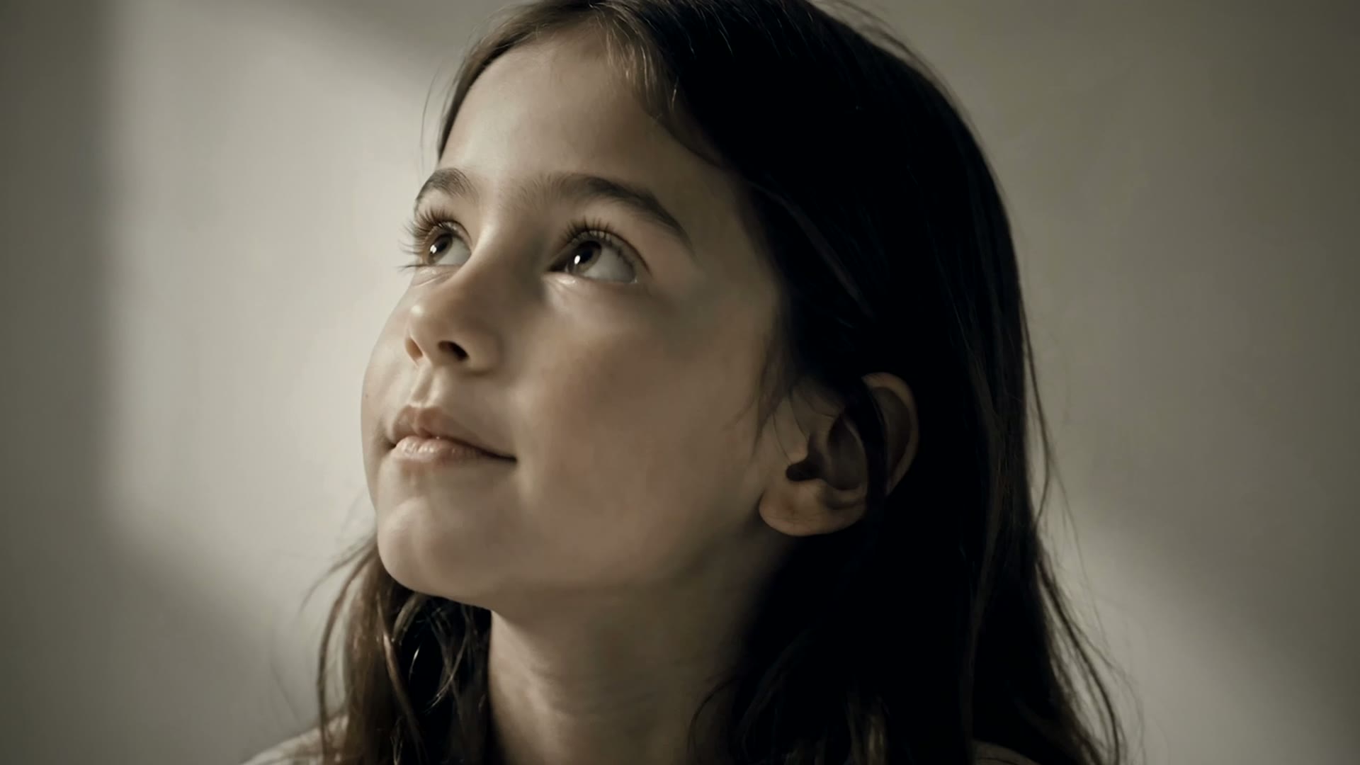 The drawn flower standing as a pale paper bloom on the table beside the child