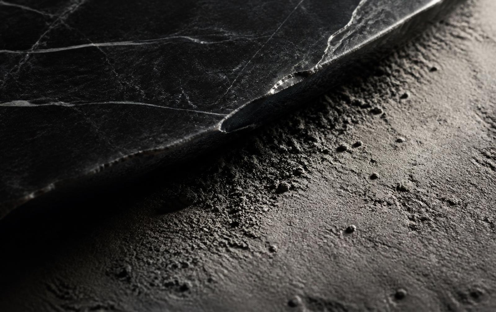 Macro detail of the contact edge between dark stone and concrete dust