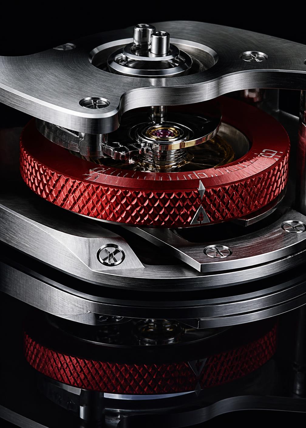 Knurled red anodised ring seated between brushed steel plates over a jewelled pivot