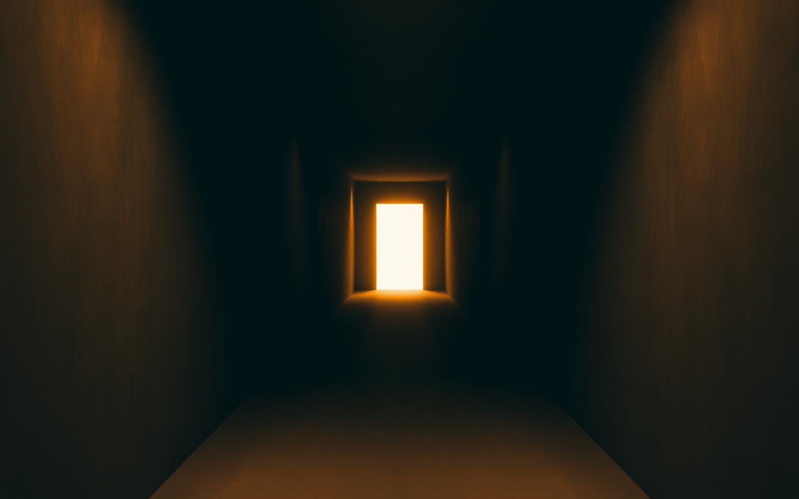 Single lit doorway at the end of a long corridor